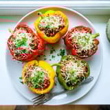 Colorful roasted Stuffed Bell Peppers, brimming with seasoned rice and ground meat, served bubbling hot from the oven.