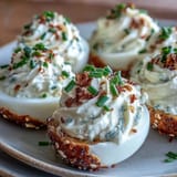 Plated everything bagel deviled eggs topped with fresh chives and seasoning.