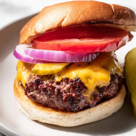 Perfectly juicy hamburgers served hot with crisp lettuce and condiments for a backyard BBQ.