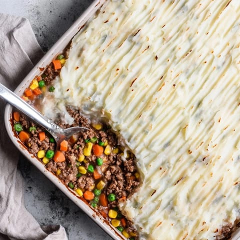 Bubbling Shepherd's Pie casserole with a fork-swirled mashed potato topping, served in a rustic baking dish.