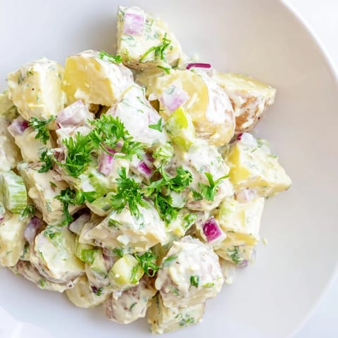 Creamy and tangy Potato Salad with tender potatoes, celery, and fresh parsley, perfect for summer barbecues.