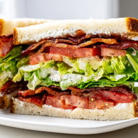 Golden toasted bread layered with crispy bacon, fresh lettuce, and juicy red tomato slices, showcasing the classic BLT Sandwich.