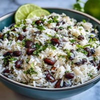 Fluffy coconut lime rice piled high with black beans, cilantro, and bright lime zest.